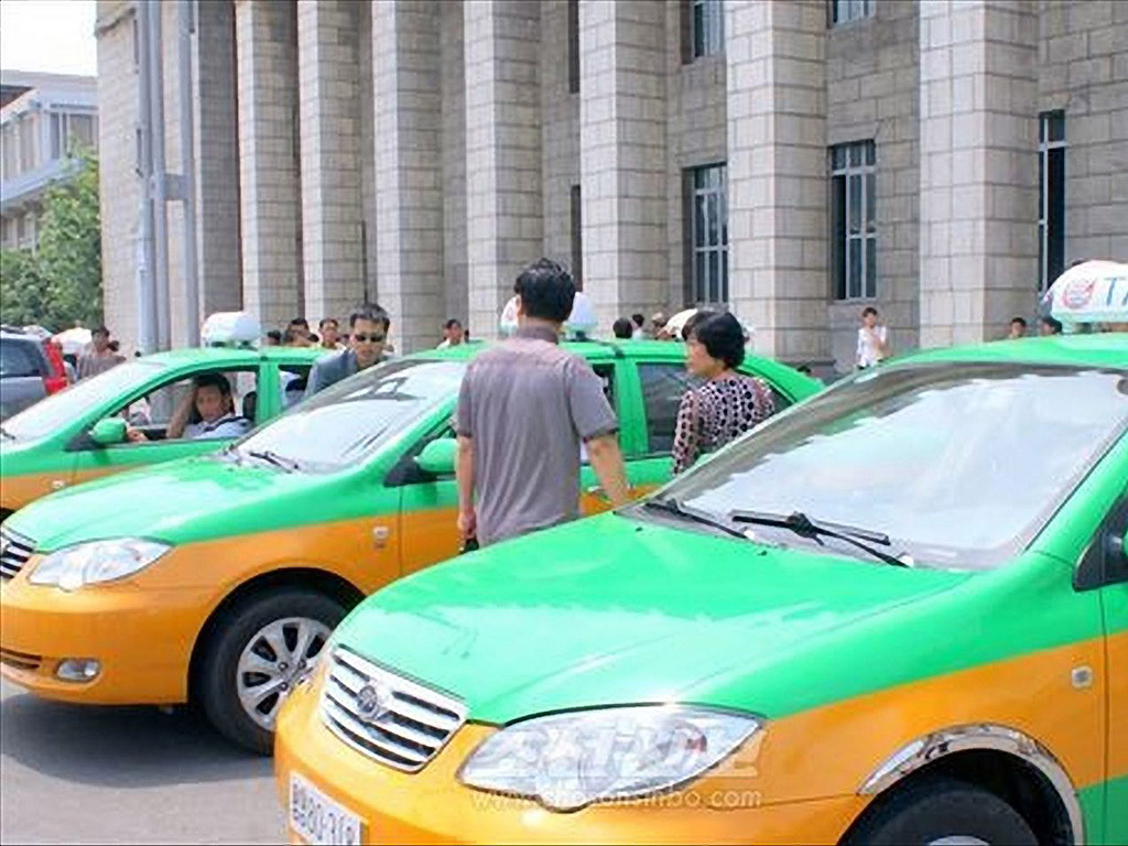 Таксита чакат клиенти пред жп гара Пхенян в Пхенян, Северна Корея. Клиентите могат да използват кредитни карти и да повикат свободно такси