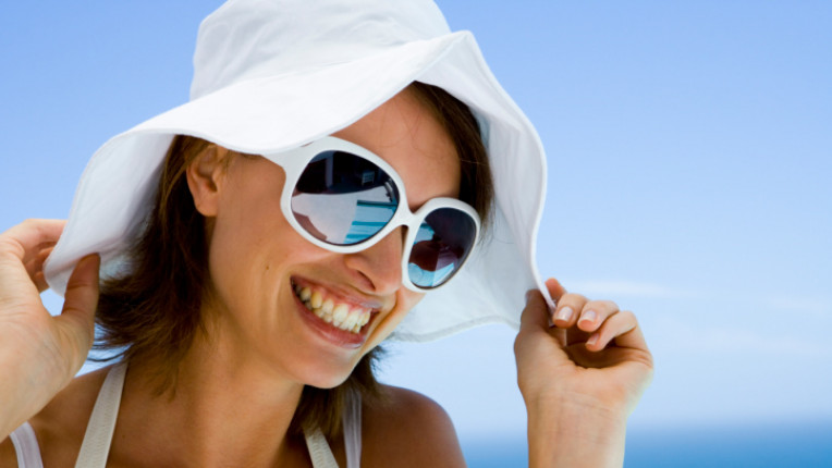 жена очила шапка слънце море