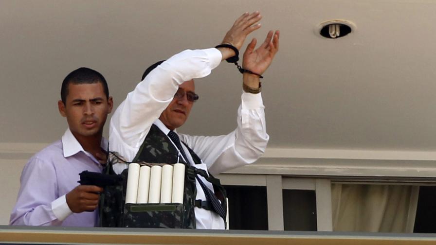 Телевизионни кадри показаха нападателя с пистолет и заложника да се появяват на балкона на стаята