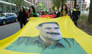 Кюрдски демонстранти носят знаме с лика на Абдуллах Йоджалан по време на протест в Хага