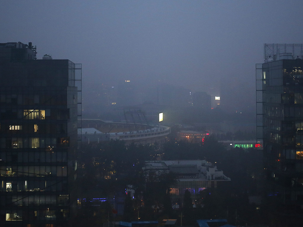 Сградите са забулени в смог в Пекин, Китай. Тежкото замърсяване продължава да бъде като одеяло над Пекин, индекса на качеството на въздуха е оцененено като тежко нездравословно през целия ден.