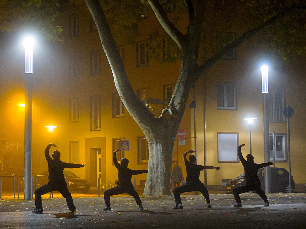 Хора практикуващи кунг-фу в мъглата на Саарбрюкен, Германия. Два пъти в седмицата хората се срещат на площада, за да практикуват бойното изкуство