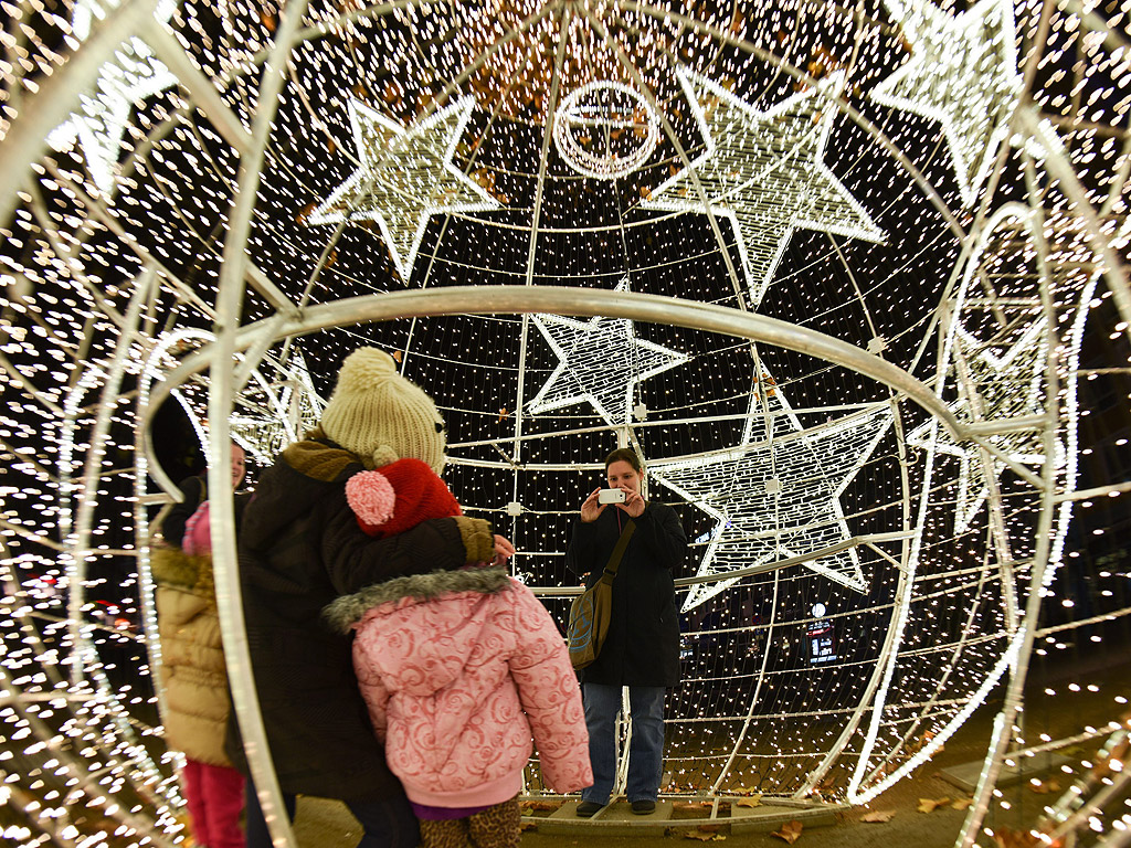 Посетители се снимат в пет-метрова осветена коледна топка в Лудвигсхафен, Германия.