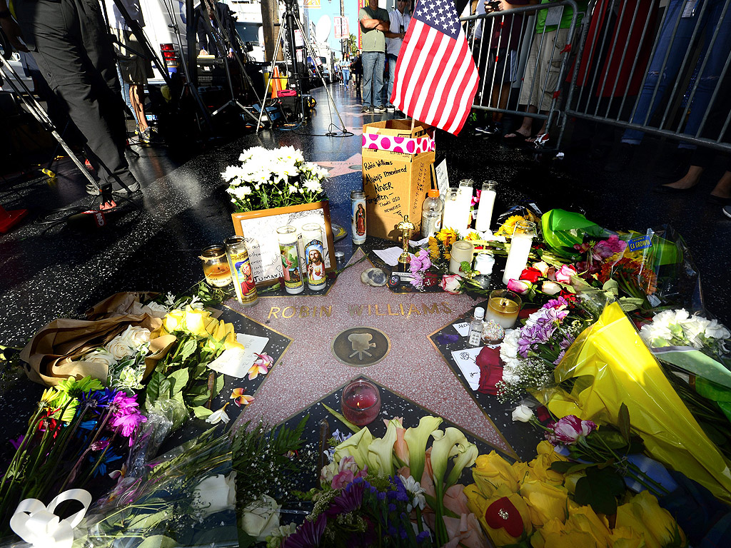 Цветя и свещи са оставени на звездата на Робин Уилямс на алеята на славата в Холивуд, Калифорния, след новината за внезапната смърт на актьора на 11 август