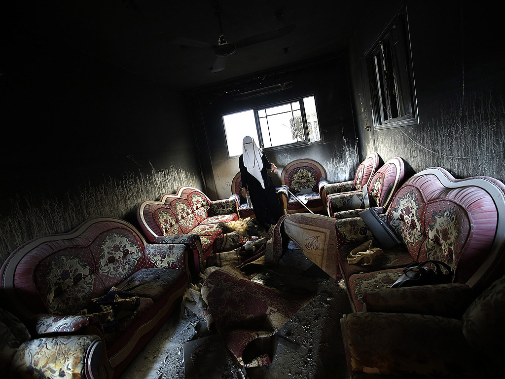 Палестинка оглежда щетите по къщата си след бомбардировка в Ивицата газа на 11 август.