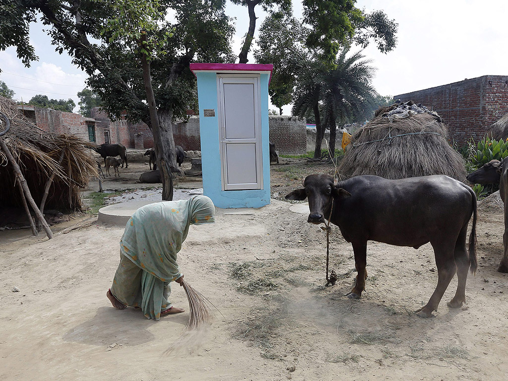 Жена мете край новата си тоалетна в двор в индийско село на 31 август. Тоалетната е монтирана от индийска неправителствена организация в рамките на кампанията „Тоалетна за всеки дом“.