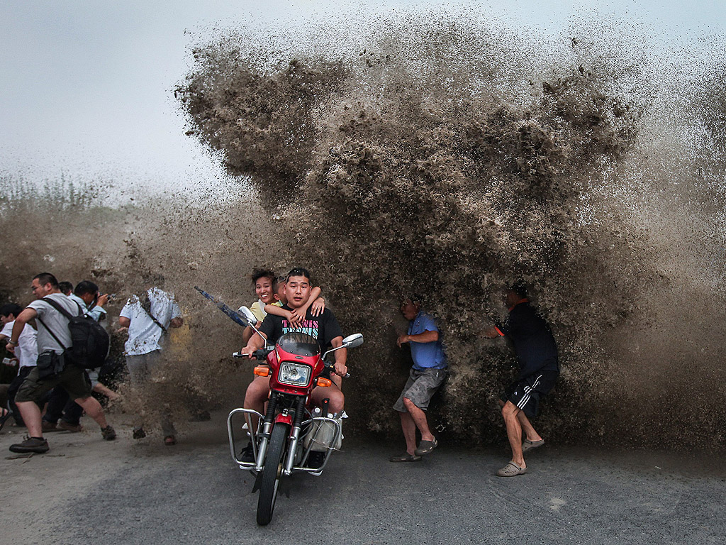 Хора бягат от голяма приливна вълна, разбила се в бреговете на река в китайската провинция Джъдзян на 13 август