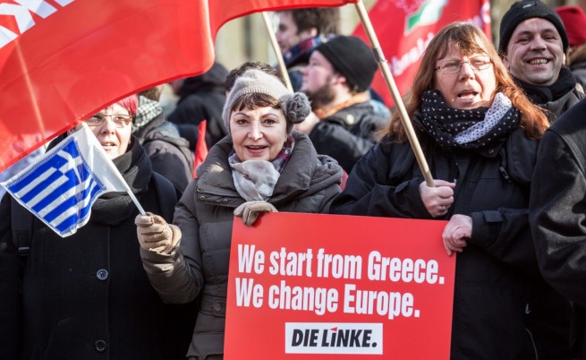 Демонстранти в Берлин по време на визитата на Янис Варуфакис носят плакат с надпис: Започнахме от Гърция, променяме Европа