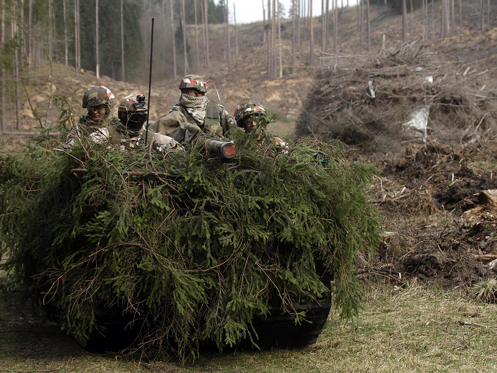 Латвийски национални гвардейци направляват напълно замаскирано превозно средство по време на военно учение в Jekabpils, Латвия. Националната гвардия (Zemessardze на латвийски) е част от въоръжените сили на Латвия и е съставена от доброволци. Заради кризата в Украйна все повече хора искат да се включат в Националната гвардия