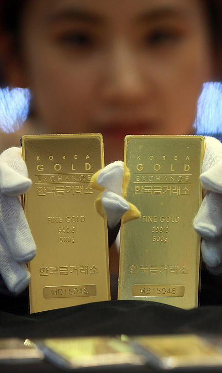 Работник държи две златни кюлчета на борсата в Сеул, Южна Корея. Все по притеснени за потенциален гръцки фалит, инвеститорите се обръщат към златото като сигурен актив, според съобщения в медиите