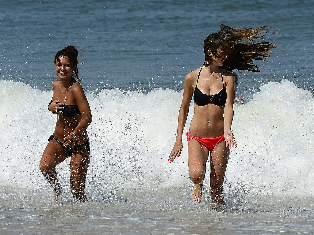 Момичета се разхлаждат в морския прибой на плаж в югозападна Франция. Температурите достигнат високо ниво и се очаква трайна гореща вълна във Франция, с максимални температури между 37 и 40 градуса в много части на страната, както и голяма част от Западна Европа