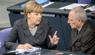 Германският канцлер Ангела Меркел говори с финансовия министър Волфганг Шойбле по време на гласуването