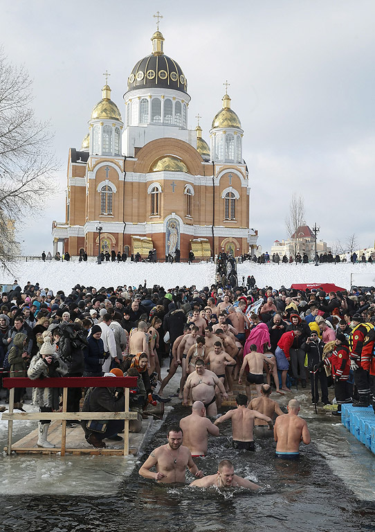 Православни вярващи се къпят в студена вода по време на Богоявленски тържества в Киев, Украйна. По време на Богоявление, някои хора вярват, че водите имат специални лечебни свойства и могат да бъдат използвани за лечение на различни заболявания, а много от тях правят ледени бани, като част от празника