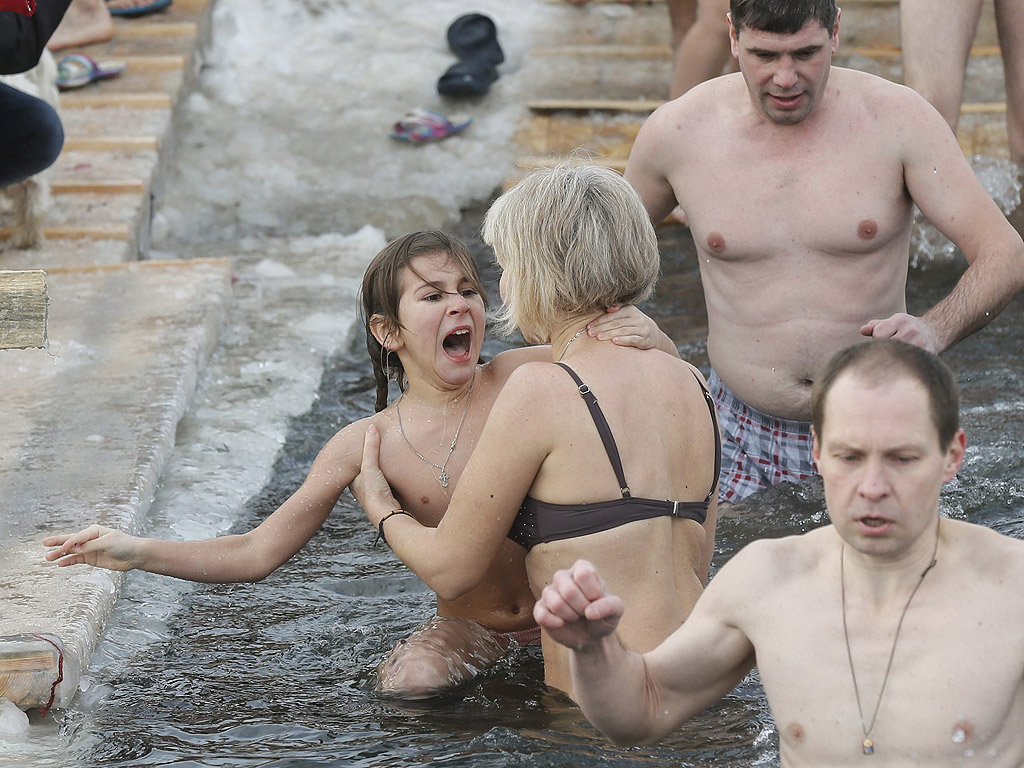 Православни вярващи се къпят в студена вода по време на Богоявленски тържества в Киев, Украйна. По време на Богоявление, някои хора вярват, че водите имат специални лечебни свойства и могат да бъдат използвани за лечение на различни заболявания, а много от тях правят ледени бани, като част от празника