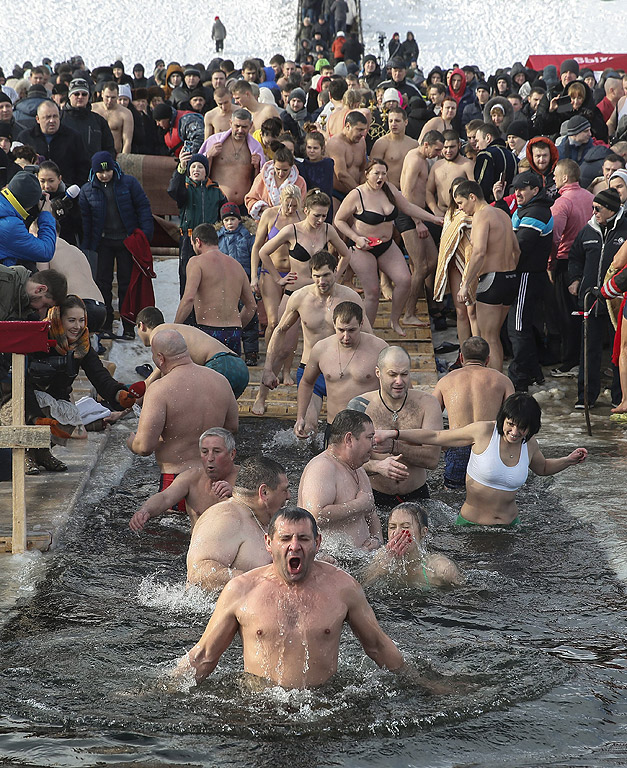 Православни вярващи се къпят в студена вода по време на Богоявленски тържества в Киев, Украйна. По време на Богоявление, някои хора вярват, че водите имат специални лечебни свойства и могат да бъдат използвани за лечение на различни заболявания, а много от тях правят ледени бани, като част от празника
