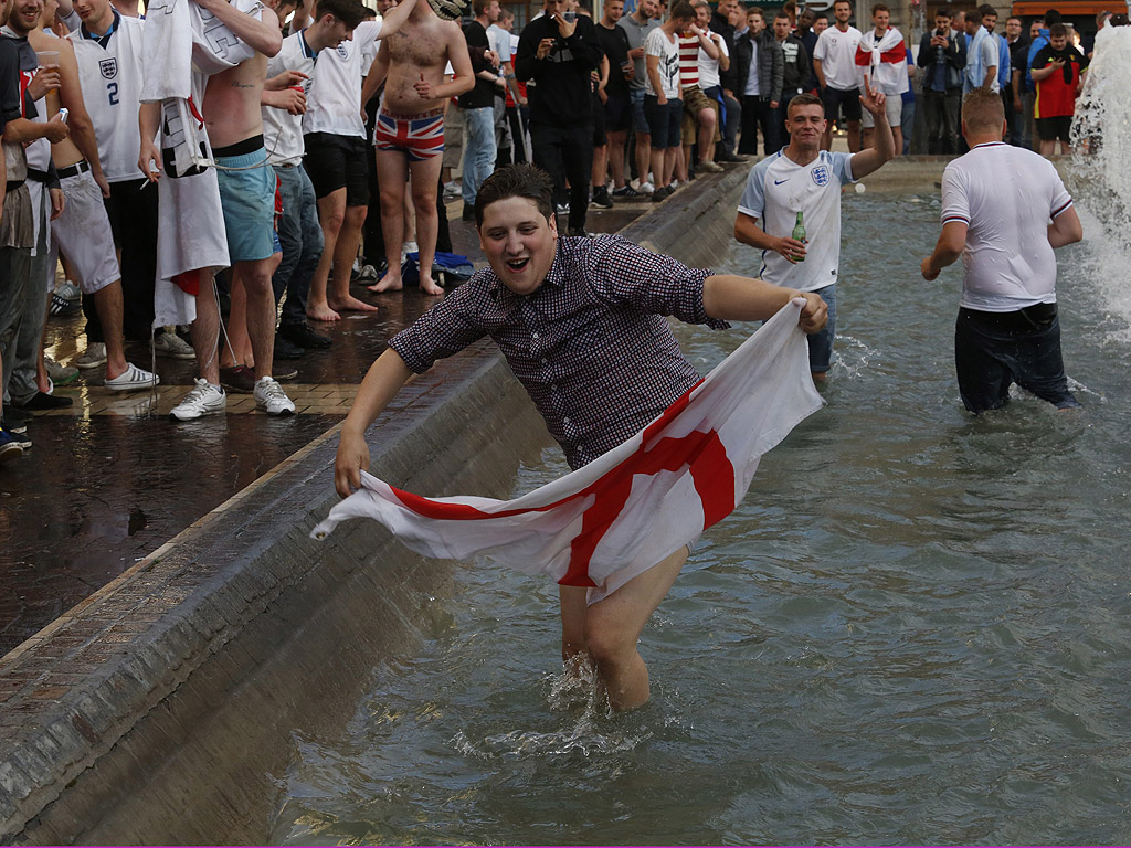 Английски футболни фенове скачат във фонтан в Лил, Франция, след мача между Англия и Уелс.
