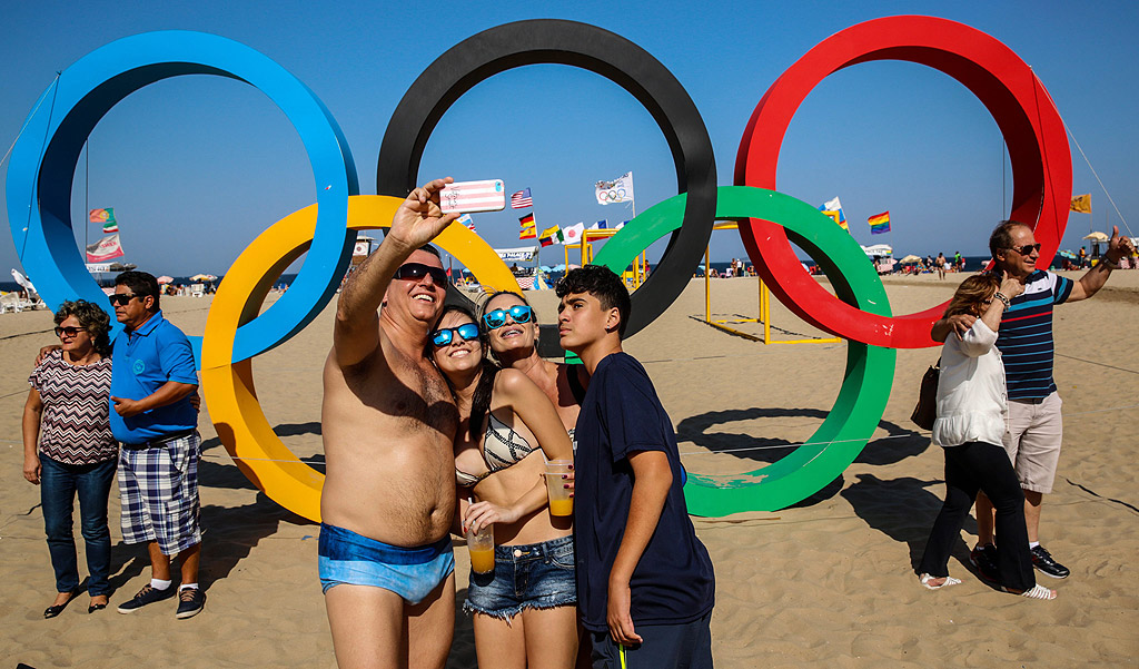 Хора си правят снимки пред олимпийските кръгове, създадени от рециклирани материали, на плажа Копакабана в Рио де Жанейро, Бразилия. Олимпийските игри в Рио започват на 5 август