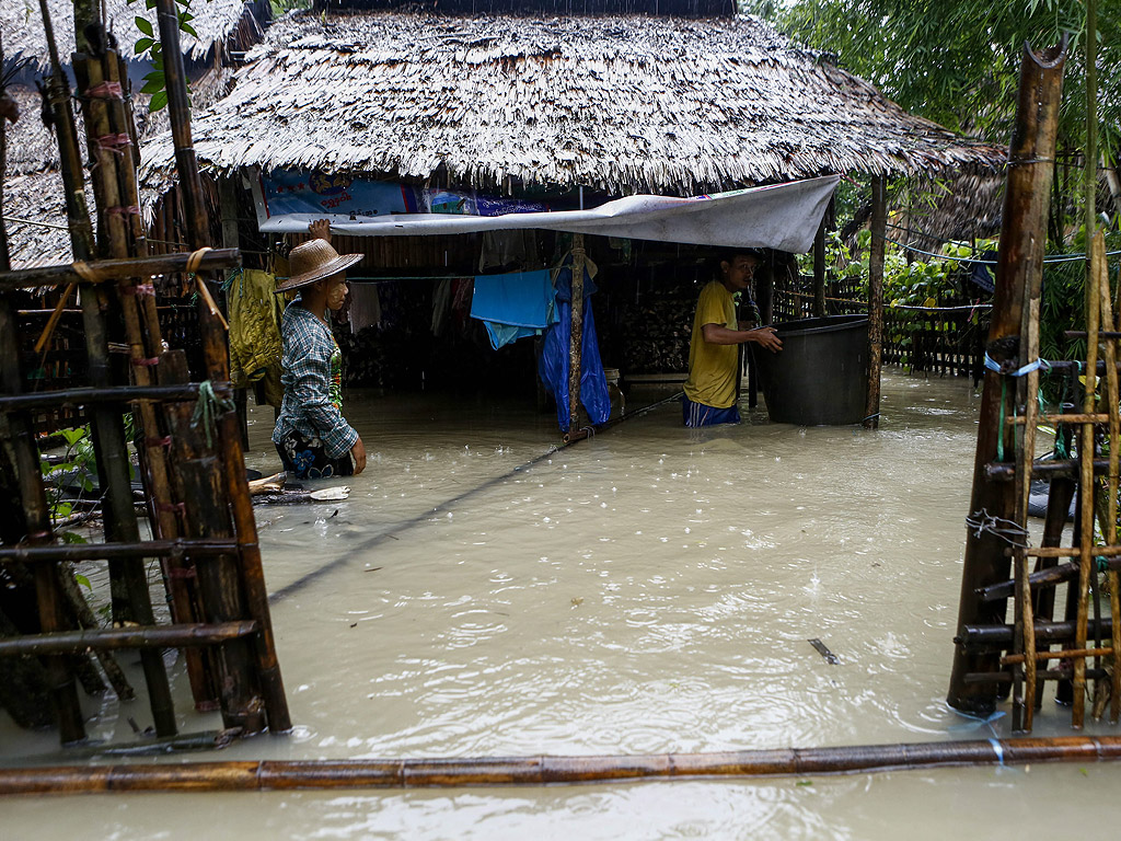Хора в наводнена къща в село Kyein Chaung в региона на Айеярди, Мианмар. Според държавните медии в Мианмар повече от 300,000 души са засегнати от наводнения, които потопиха общо 703 села