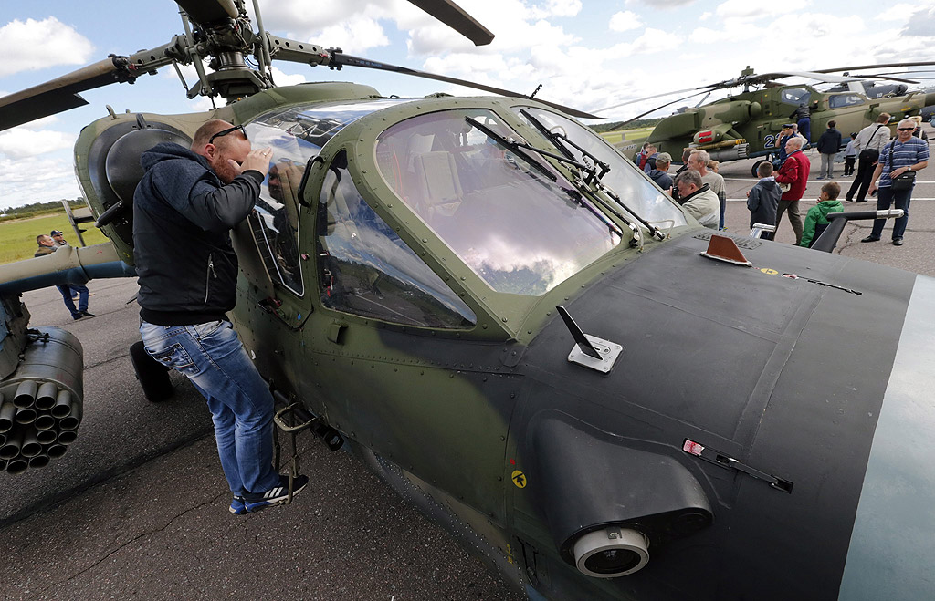 Посетители разглеждат руския KA-52 "Alligator" боен хеликоптер по време на Авиошоу близо до Санкт Петербург, Русия, за Деня на руските ВВС