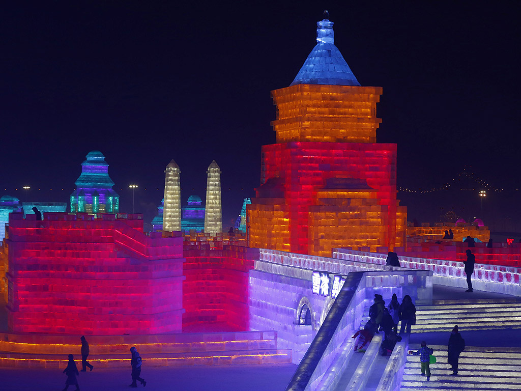 Хора посещават скулптури от лед осветени от цветни светлини на 33-ия Международен фестивал на леда и снега в град Харбин в китайската северна провинция Хъйлундзян. 180,000 кубични метра лед и 150,000 кубически метра сняг са използвани за изграждане на скулптурите. Фестивалът ще продължи близо три месеца.