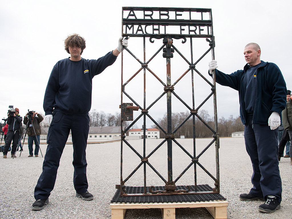 Работници показват желязната порта с надписа "Arbeit Macht frei" (Работата ще те освободи) след завръщането й в лагера Дахау, Германия. Портата бе намерена от полицията в Норвегия, две години след като бе открадната на 2 ноември 2014. Вратата ще бъде изложена на показ в музея, а на нейно място има готова реплика