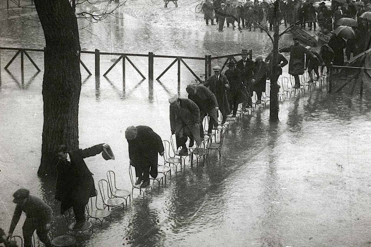 В края на януари 1910 г. след месеци на обилни валежи във Франция, в Париж река Сена пълни канализационните канали, тунелите на метрото, проправя си път до мазетата на хората и пропива напълно почвата.
За разлика от близките градчета, в които буйната река излиза от коритото си и залива всичко заобикалящо я, в Париж тя сякаш извира от самия град, за да го наводни.
За 10 дни водата достига до най-високото си ниво, а на 35-ия изчезва напълно. За щастие наводнението не отнема нито един живот. За сметка на това нанася щети на стойност над 400 млн. франка, равняващи се днес на 1.5 млрд.