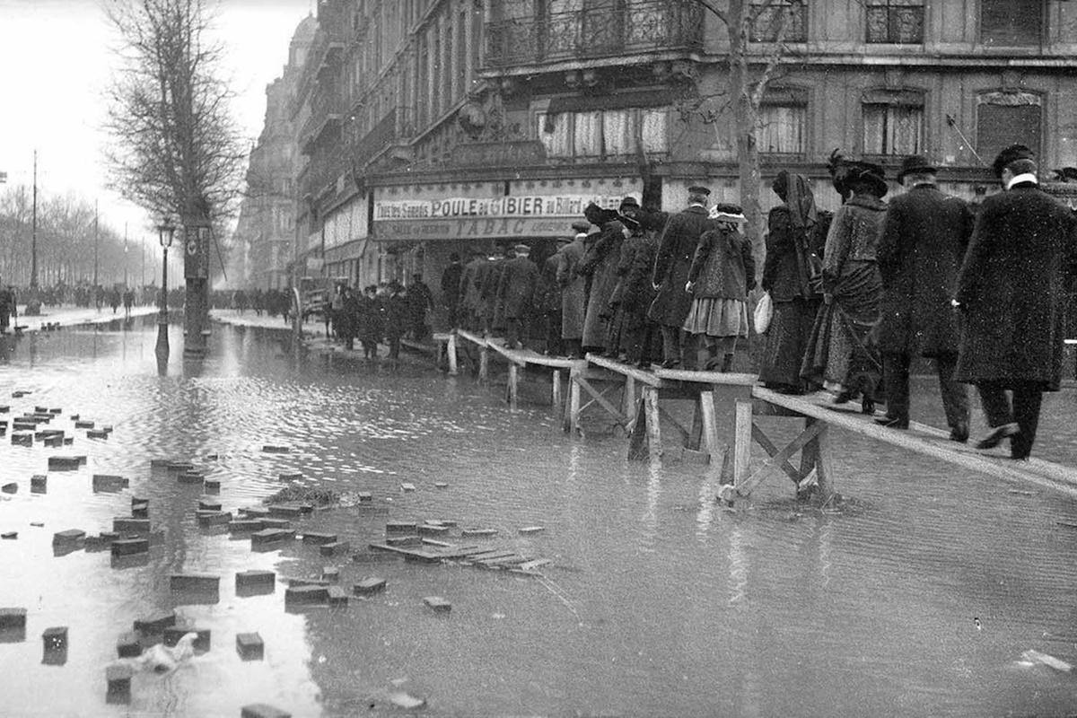 В края на януари 1910 г. след месеци на обилни валежи във Франция, в Париж река Сена пълни канализационните канали, тунелите на метрото, проправя си път до мазетата на хората и пропива напълно почвата.
За разлика от близките градчета, в които буйната река излиза от коритото си и залива всичко заобикалящо я, в Париж тя сякаш извира от самия град, за да го наводни.
За 10 дни водата достига до най-високото си ниво, а на 35-ия изчезва напълно. За щастие наводнението не отнема нито един живот. За сметка на това нанася щети на стойност над 400 млн. франка, равняващи се днес на 1.5 млрд.