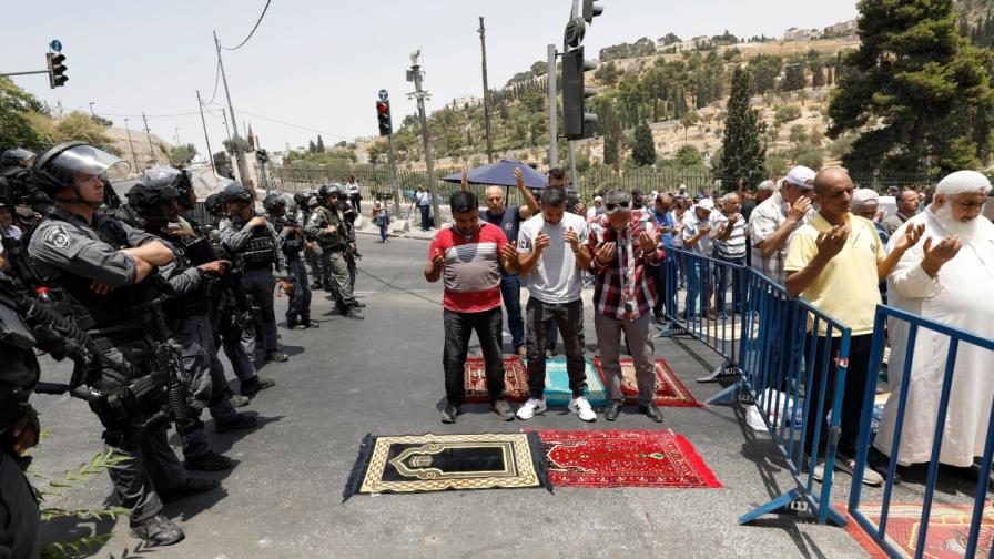 Мюсюлмани се молят пред погледа на израелски войници преди детекторите за метал, поставени пред джамията "Ал Акса"