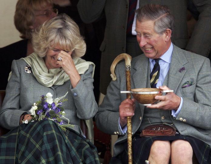 <p>Принц Чарлз и Камила Паркър-Боулс се смеят до сълзи, когато трябва да пият уиски, поднесено им като сватбен подарък при посещението им в Кейтнес, Шотландия, през 2005 г.</p>