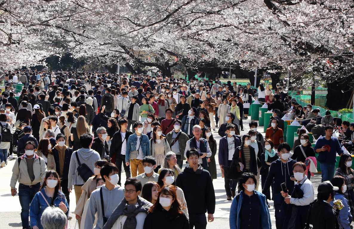 <p>Посетители, носещи маски, се разхождат под цъфналите череши в парк Ueno в Токио, Япония.</p>