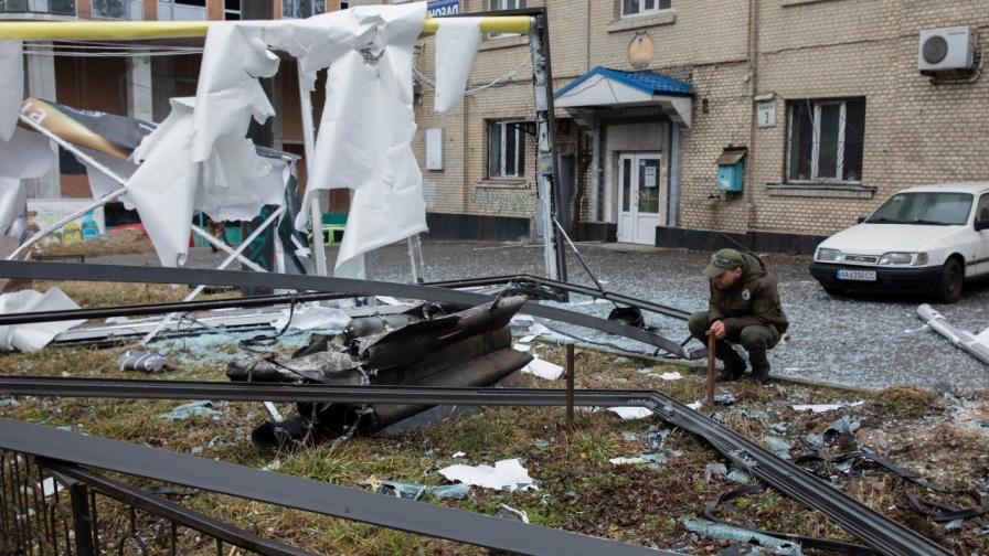 Мъж разглежда отломките от неидентифициран обект след експлозия в Киев, Украйна