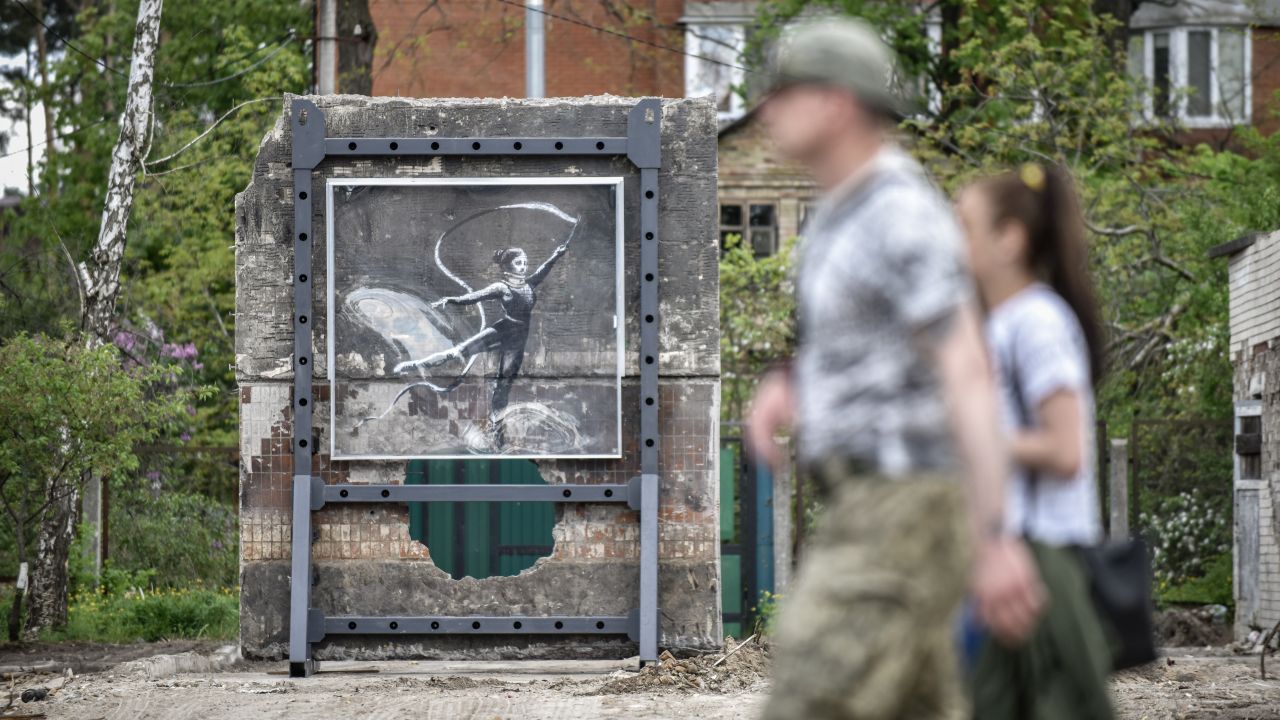 <p>Хора минават покрай графит на британския уличен художник Банкси, поставен на ново място в Ирпин, след като е премахнат от повредена сграда, която трябва да бъде съборена.</p>