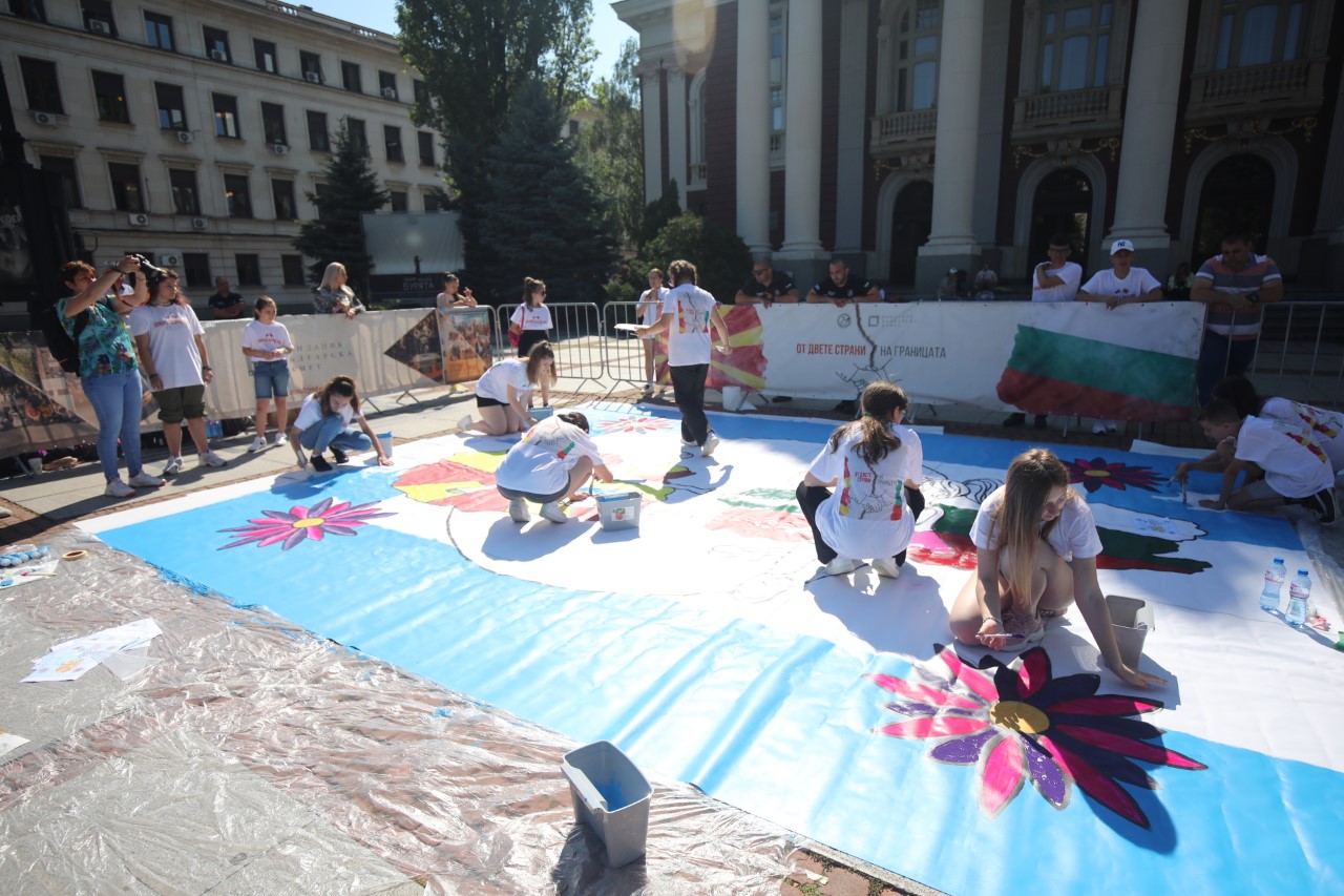 <p>Млади художници от България и Северна Македония рисуват голяма картина пред сградата на Народния театър &bdquo;Иван Вазов&ldquo; в София, символизираща стремежа към единство между двете държави.</p>