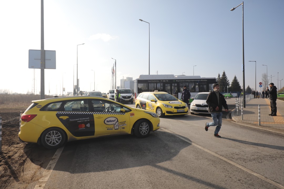 <p>Протестиращи таксиметрови шофьори се струпаха в района на Терминал 2 на летище София. От аеропорта предупредиха пътниците да си дадат повече време и да пристигнат на летището поне 3 часа преди конкретния полет. Таксиметровите шофьори от Национален таксиметров синдикат недоволстват от новата организация на движението на аеропорта.</p>