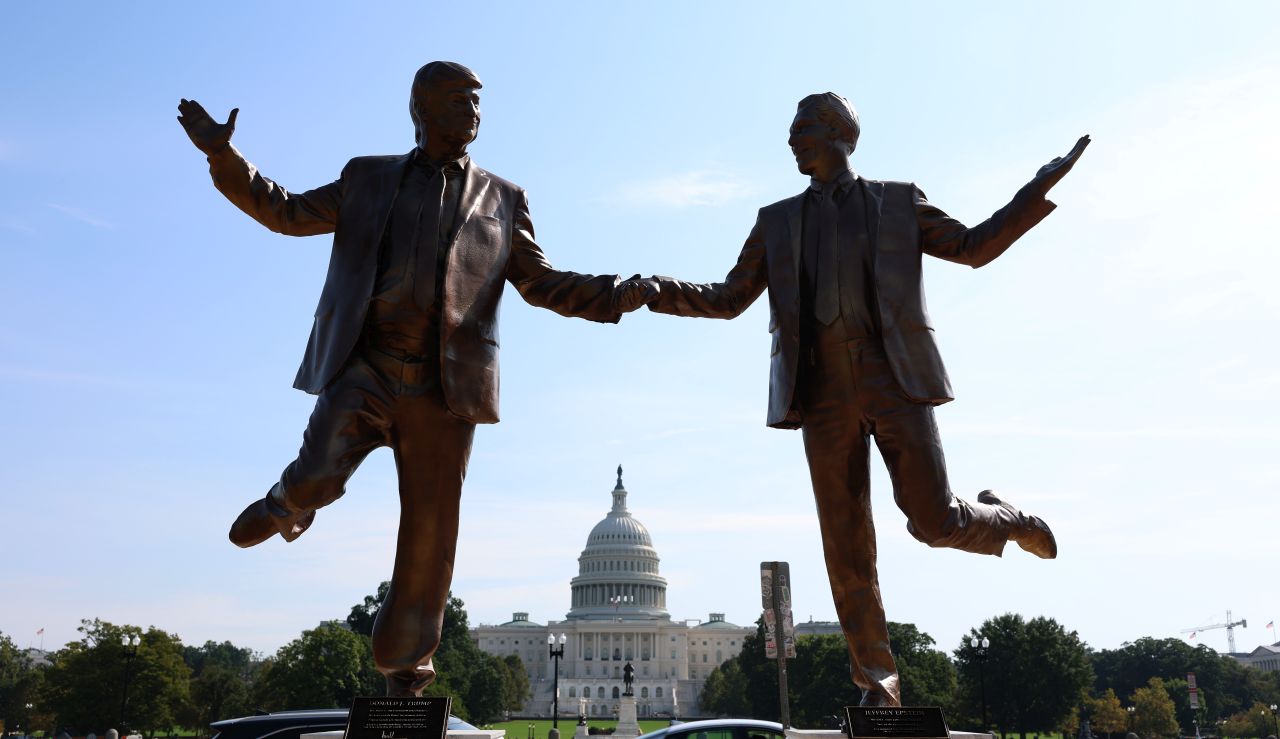 <p>Галерията представя новата бронзова статуя на National Mall, изобразяваща Доналд Тръмп и Джефри Епстийн в радостна поза. Инсталацията предизвика оживени реакции и дискусии, като акцентира върху миналата връзка между президента и осъдения трафикант.</p>