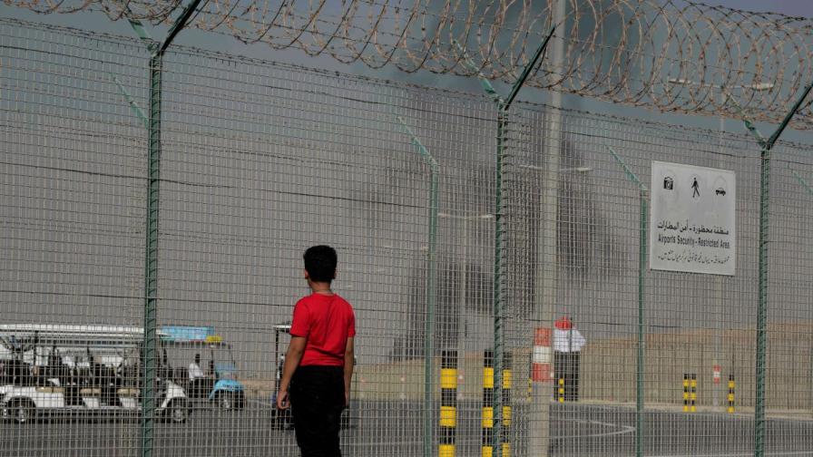 Минувач наблюдава дима, издигащ се след катастрофата с индийнски изтребител по време на авиошоу в Дубай, 21 ноември 2025 г.