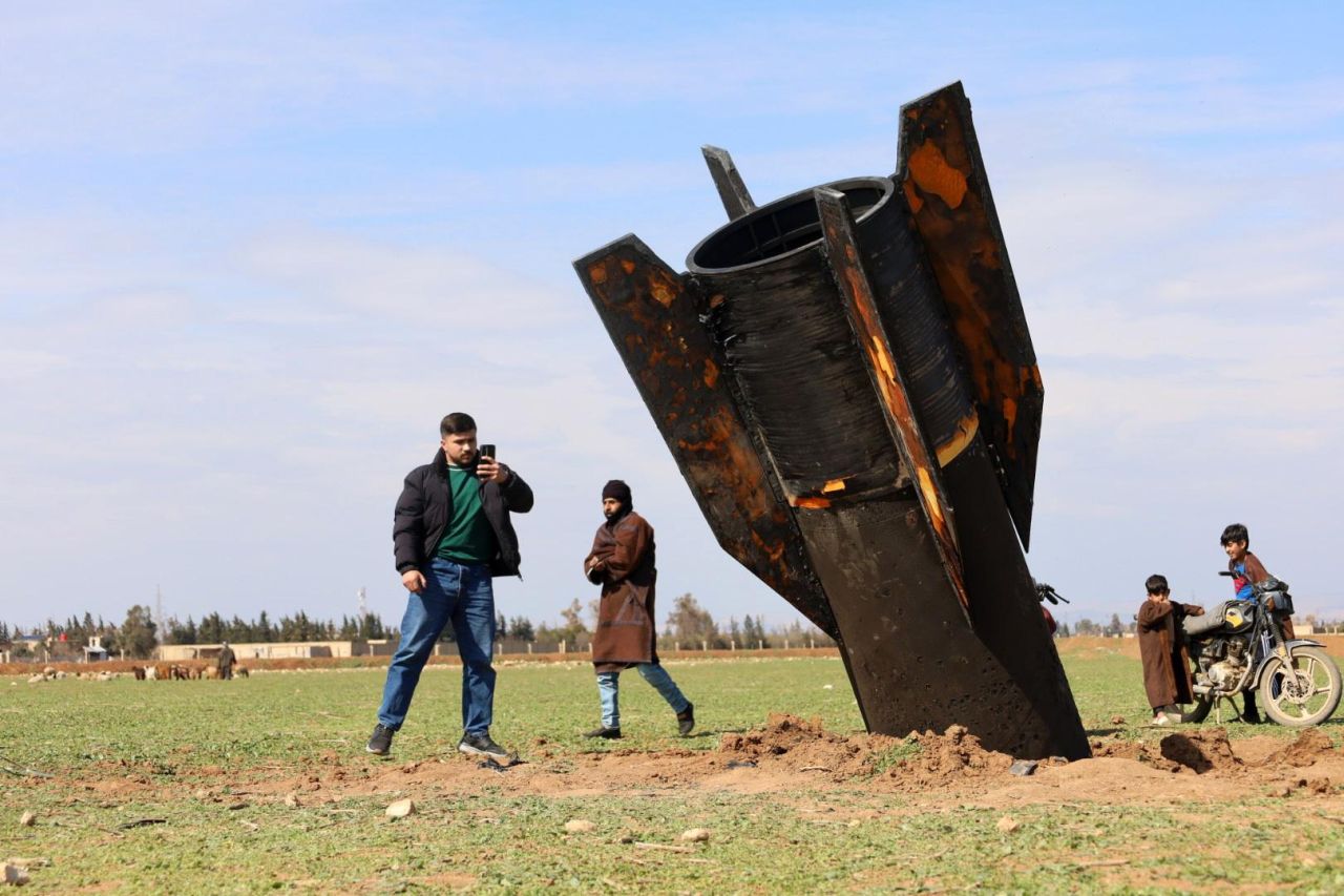 <p>Хора стоят до иранска ракета, паднала в село Казалжо в покрайнините на град Камишли, Сирия. Иран предприе ответни атаки в целия регион след съвместна военна операция на Израел и САЩ, която започна в ранните часове на 28 февруари 2026 г. и порази множество цели на територията на Иран.</p>