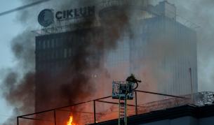 Огнеборец гаси пожар в офис сграда, поразена при руски удар с дронове в украинската столица Киев, 25 септември 2026 г.