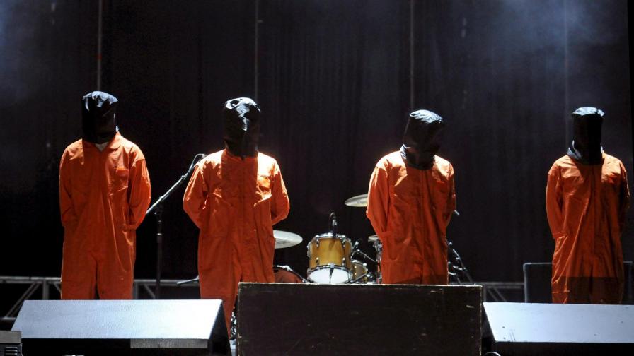 Музикантите от "Рейдж ъгейнст дъ машин" облечени като затворници от Гуантанамо по време на концерт.