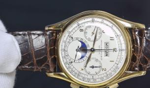 Служител на "Кристис" показва уникалния златен часовник, продаден за рекордната сума