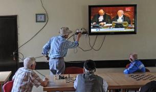 Косовски албанци гледат по телевизията изчитането на становището на Международния съд в Хага