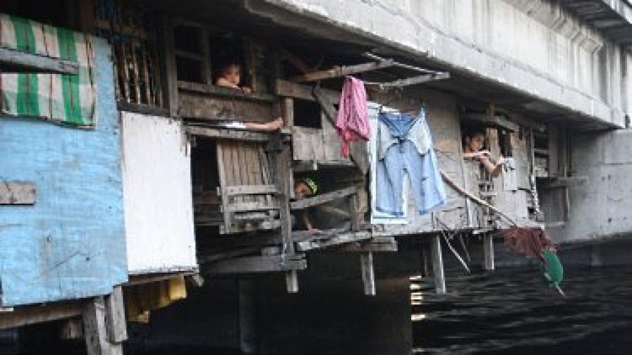 Филипинци живеят в бараки под моста в очакване на наводненията след тайфуна, който вече удари северната част на страната