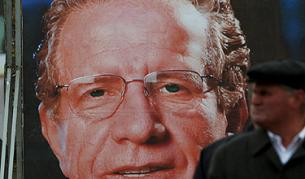 Етнически албанец минава покрай предизборен плакат на Беджет Пацоли