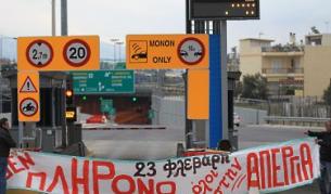 Последователи на движението разпъват транспарант с надпис: "Аз не плащам. Всеобща стачка на 23 февруари" пред пункт за заплащане на пътна такса в Атина