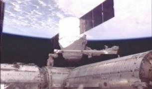 Частният космически кораб "Дракон" по времена разкачването от МКС, извършено с  помощта на 17-метрова ръка-манипулатор