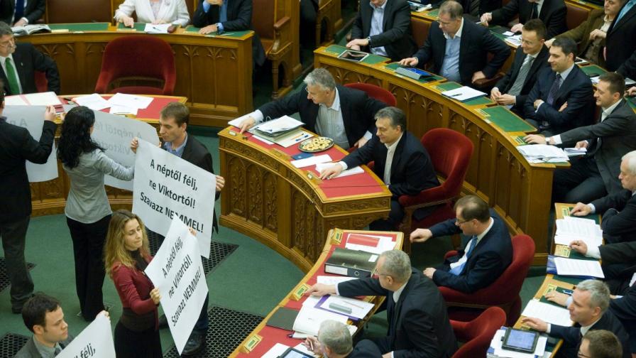 Докато унгарските депутати от мнозинството гласуват, членове на опозиционната партия "Диалог за Унгария" застанаха с протестни плакати срещу тях. Промените в конституцията бяха утвърдени с гласовете на 68,8% от депутатите.