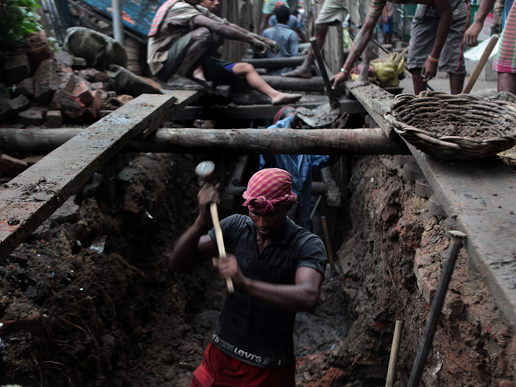 Индийци работят по подновяването на мръсната канализация в Колката. Новите тръби ще заменят поставените по времето на Британската империя преди триста години.